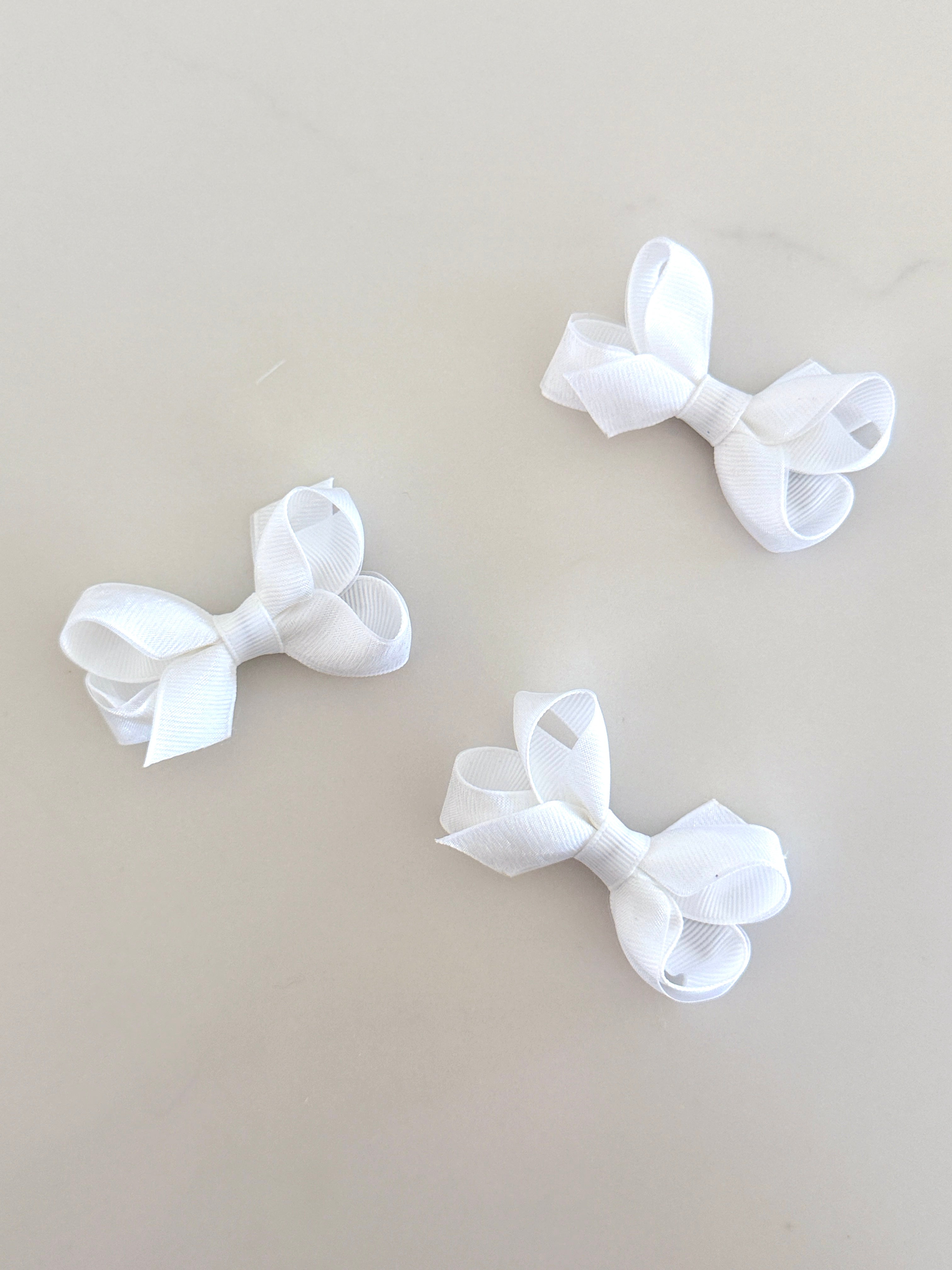 Tiny white overlay bow