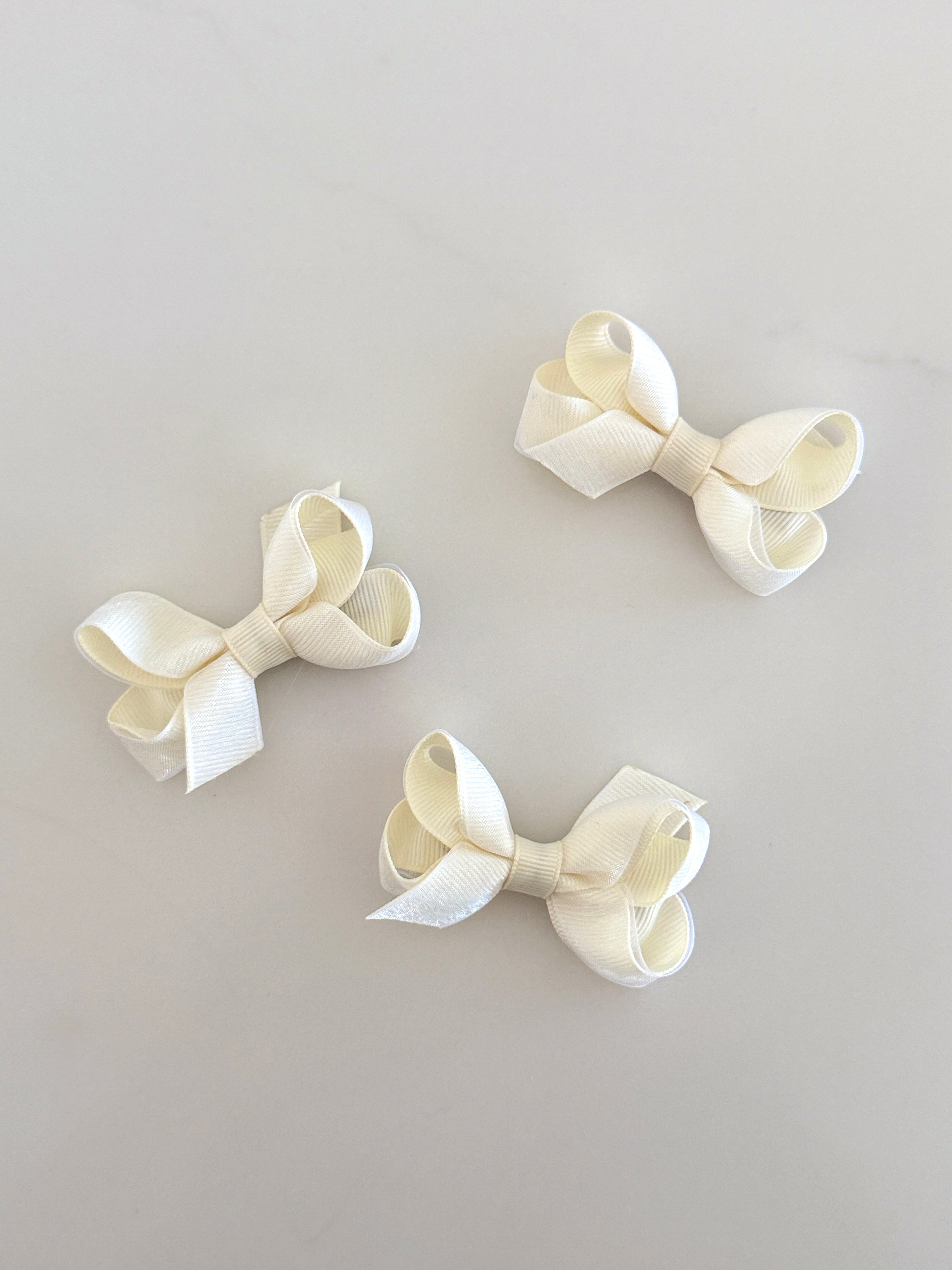 Tiny cream overlay bow